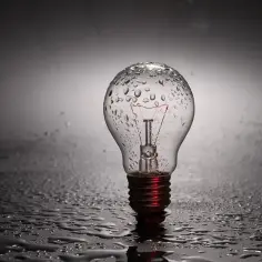 Kto wynalazł żarówkę? Ta mokra, szklana bańka z widocznym żarnikiem symbolizuje iskrę geniuszu, która rozświetliła świat.