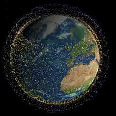 Ziemia otoczona tysiącami kolorowych punktów, symbolizujących satelity Starlink i inne obiekty na orbicie.