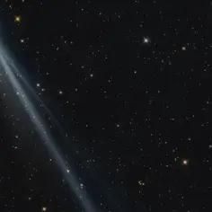 Zielona kometa z długim, jasnym ogonem przecina ciemne, gwieździste niebo.