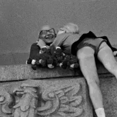 22 lipca. Uśmiechnięty mężczyzna w okularach obejmuje dziewczynę, która kładzie mu głowę na ramieniu. W tle widać wieniec.