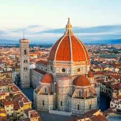 Widok na katedrę Santa Maria del Fiore we Florencji, z jej charakterystyczną kopułą i dzwonnicą Giotta, otoczoną dachami miasta.