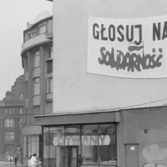 Transparent na budynku z napisem "Głosuj na Solidarność" symbolizuje upadek komunizmu i nadzieję na wolność.