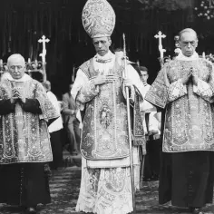 Trzech duchownych w bogato zdobionych szatach, jeden w tiarze, symbolizuje papieży XX wieku podczas uroczystości.