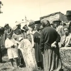 Grupa ludzi, w tym dzieci, stoi przy nagrobkach. Wśród nich są karaimi, którzy wspominają swoich przodków.
