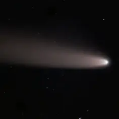 Jasna kometa Halleya z długim, rozmazanym ogonem na tle ciemnego, gwieździstego nieba.