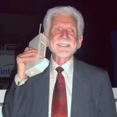 Martin Cooper, który wymyślił telefon komórkowy, prezentuje swój wynalazek.