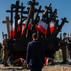 Uroczystość 1 września przy Pomniku Powstania Warszawskiego. Warty honorowe i mężczyzna w garniturze oddają hołd.